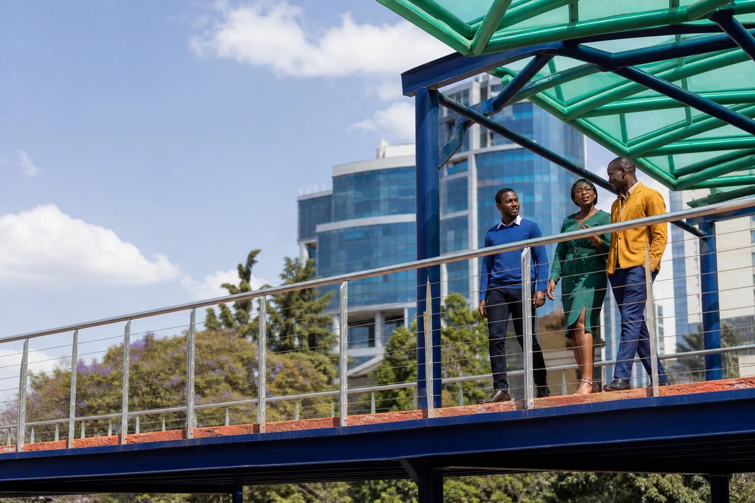Professionals walking across a Nairobi pedestrian bridge